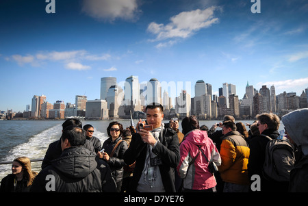 Les touristes sur la rivière Hudson New York Water Taxi avec l'horizon de Manhattan derrière. Banque D'Images