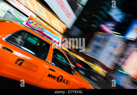 Un taxi jaune en voyageant à travers le néons de Times Square, New York City, USA Banque D'Images