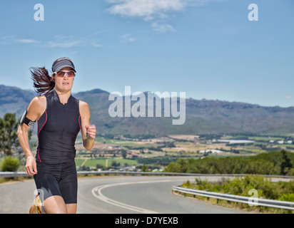 Woman running on rural road Banque D'Images