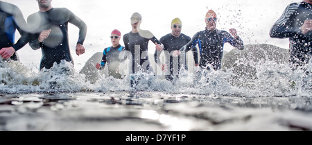 Triathletes emerging from water Banque D'Images