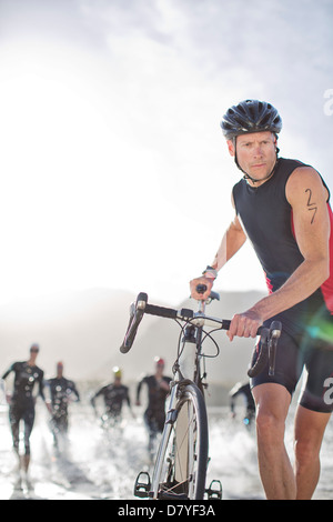 Man pushing bicycle on beach