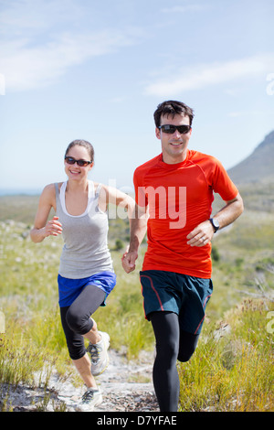 Couple running in rural landscape Banque D'Images