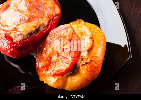 Poivrons farcis à la viande hachée, de fromage et de tomates sur la plaque noire Banque D'Images