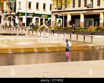 Jeune fille jouant de la pagaie dans l'eau à fontaine dans le centre-ville de Nottingham, Nottinghamshire, Angleterre, Royaume-Uni Banque D'Images