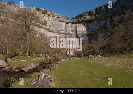 Vue panoramique ensoleillée de l'eau dans beck par Malham Cove sous ciel bleu - immense, transparente, courbant falaise de calcaire dans de belles vallées du Yorkshire, England, GB, au Royaume-Uni. Banque D'Images