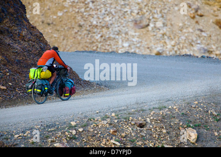 Cycliste chargé avec équipement de camping équitation la route d'accès limité au col de Thorofare, Denali National Park, Alaska, USA Banque D'Images