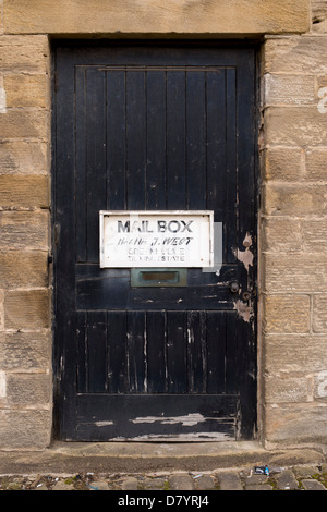 Close-up du vieux panneau en bois marquant la position de la boîte de courrier pour Mr et Mme West monté sur porte en bois avec peinture écaillée - près de Ilkley, Aquitaine, FR, UK. Banque D'Images