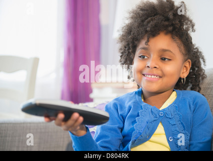 African American girl watching television on sofa Banque D'Images