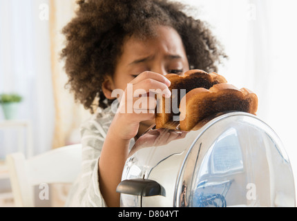 African American girl burning pain grillé au grille-pain Banque D'Images