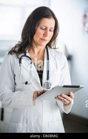 Caucasian doctor using tablet computer in office Banque D'Images