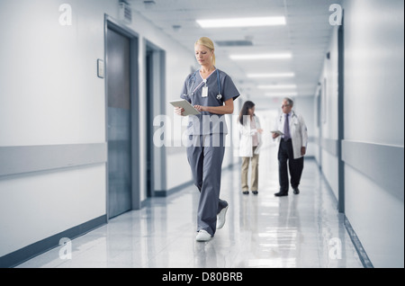 Caucasian nurse reading medical chart in hospital Banque D'Images