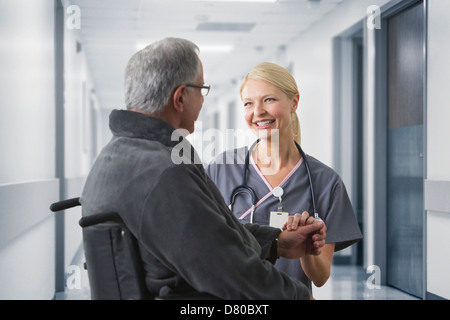 Caucasian nurse talking to patient in hospital Banque D'Images