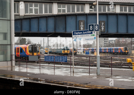 Clapham Junction plates-formes et voies de chemin de fer et de signer sous la pluie Banque D'Images