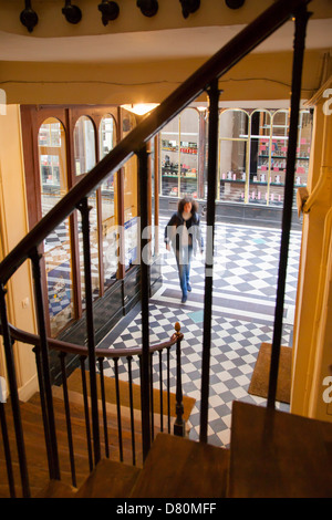 Femme marche dans un escalier à l'intérieur de la Galerie Vero-Dodat - un des passages couverts dans le 2ème arrondissement, Paris France Banque D'Images