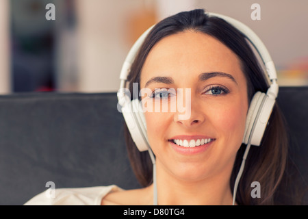 Portrait de femme simling avec son casque. elle écoute de la musique Banque D'Images