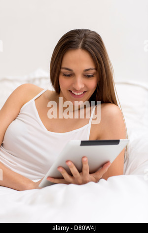 Jeune femme naturel surf sur internet avec tablet pc dans la chambre Banque D'Images