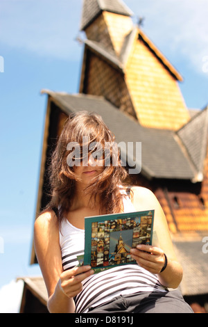 Une jeune touriste, c'est l'inscription d'une brochure à propos de Heddal stave church tout en étant assis en face de celui-ci lors de l'Notodden Blues Festival. Banque D'Images