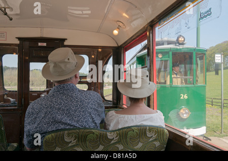 Couple assis dans un tram alors qu'un autre tram passe par Beamish Museum North East England UK Banque D'Images