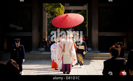 Mariage traditionnel japonais au Temple de Meiji Shinto rouge vif avec parapluie Gifu et entourage de la famille et des amis Banque D'Images