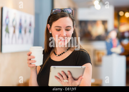 Caucasian woman using tablet computer in art gallery Banque D'Images