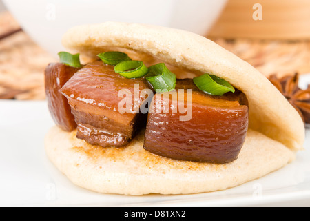 Hong Shao Rou - flan de porc braisé et caramélisées dans la sauce de soja à la badiane, la cannelle et le piment rouge à l'intérieur d'un petit pain à la vapeur. Banque D'Images