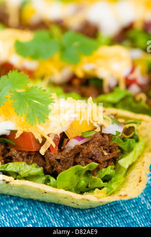 - Tacos au boeuf boeuf déchiqueté bacs taco garnies de salsa, de crème aigre et de fromage râpé. Banque D'Images