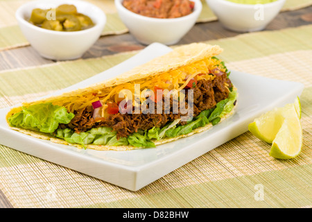 Tacos au boeuf - mexicaine tacos au boeuf haché dans des tortillas de maïs servi avec salade, crème sure, fromage cheddar, râpé et salsa Banque D'Images