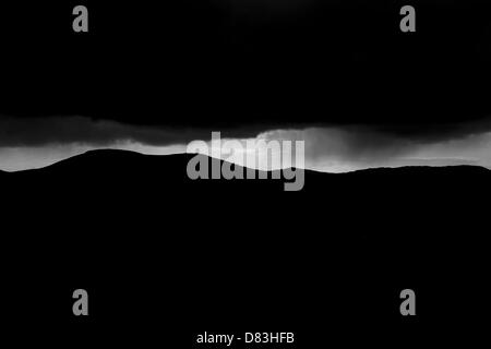 Moody skies avec des pluies bien piquer à travers les nuages sur les montagnes donnant de l'espoir et de changement pour l'avenir Banque D'Images