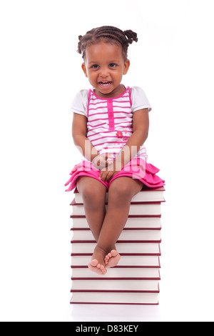 Cute black african american petite fille assise dans une pile de livres, isolé sur fond blanc - les Africains - les enfants Banque D'Images