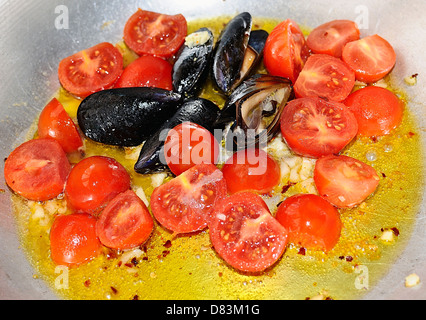 Cocotte au mélange de moules, les tomates, l'ail et l'huile Banque D'Images