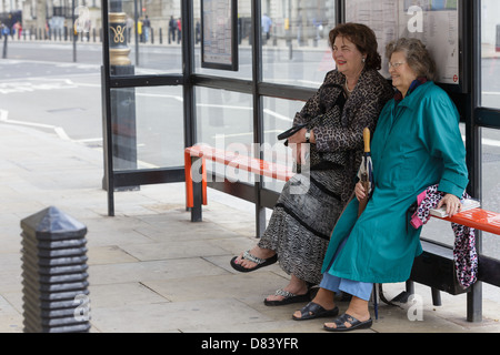 Deux femmes âgées en attendant le bus à Londres, Royaume-Uni Banque D'Images