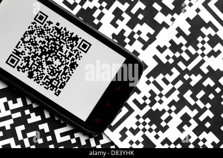 Un téléphone portable à côté de certains codes QR imprimé sur du papier Banque D'Images