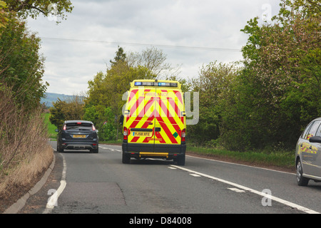 Voir à travers un pare-brise d'une ambulance avec feux bleus clignoter se précipitant pour un dépassement d'une voiture le long d'une route principale. Le Shropshire England UK Banque D'Images