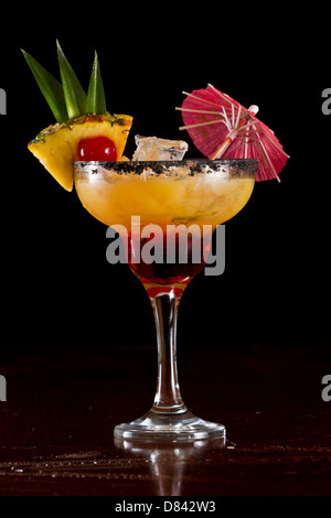 Belle tropical cocktail servi dans un verre à margarita sel noir sur la jante et une tranche d'ananas avec une cerise dans c Banque D'Images