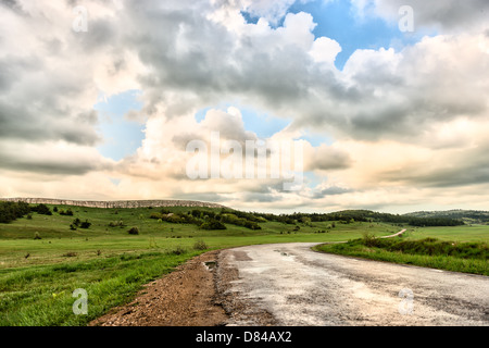 Route asphaltée et ciel nuageux sur un plateau de montagne. Banque D'Images