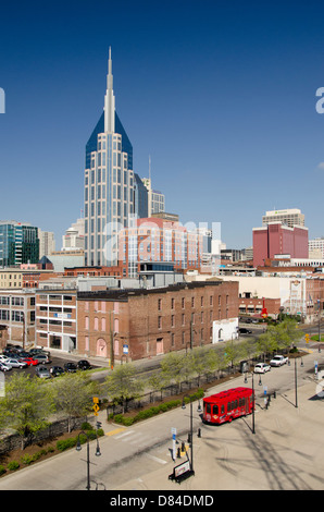 New York, Nashville. Le centre de Nashville skyline avec red 'Music City Trolley' hop-on hop-off trolley touristique. Banque D'Images
