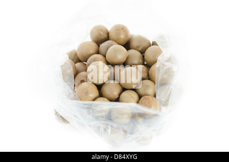 Vue de dessus dans un sac en plastique de macadamia sur fond blanc Banque D'Images