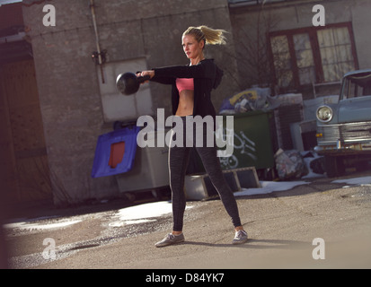 Jeune femme fitness kettlebell balançant le crossfit au cours de la formation Banque D'Images