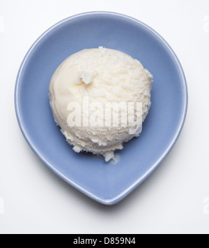 Une boule de crème glacée à la vanille dans un bol bleu Banque D'Images