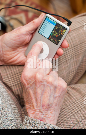 Une femme âgée à l'aide d'un iPod Banque D'Images