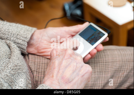 Une femme âgée à l'aide d'un iPod Banque D'Images