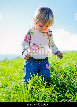 Petite fille enfant debout dans l'herbe haute à Treasures Banque D'Images