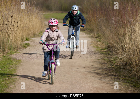 Fille et garçon à vélo dans la campagne Banque D'Images