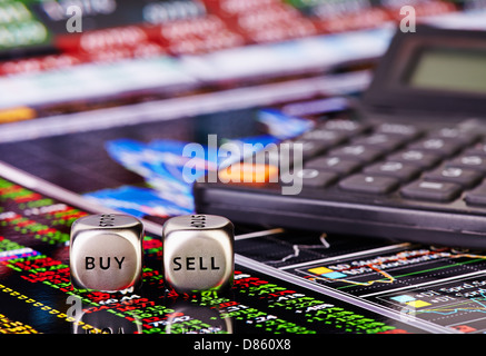 Dés cubes avec mots Vendre Acheter pour trader et Calculatrice. Tableau financier et des colonnes de chiffres comme arrière-plan. Selective focus Banque D'Images