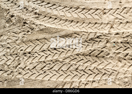 Les traces de pneus du tracteur et empreintes de pas sur le sable Banque D'Images