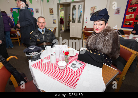 Un homme en uniforme de l'armée allemande et compagne dans un café. Haworth 1940 week-end, mai 2013. Banque D'Images