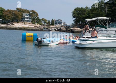 Les plaisanciers importun ancre près de cher homes sur l'île rocky shore à Long Island Sound, Connecticut USA. Banque D'Images