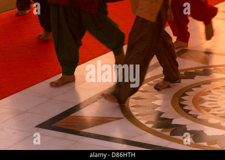 L'Inde, Punjab, Amritsar, près des pieds des pèlerins Sikhs comme ils marchent autour du Temple d'or au lever du soleil Banque D'Images