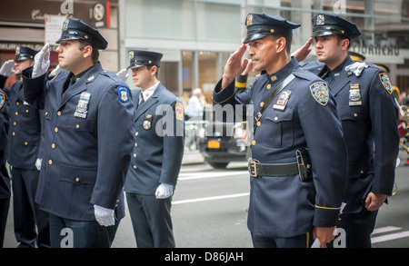 Les membres de la NYPD et FDNY au garde à vous et salue durant l'hymne national Banque D'Images