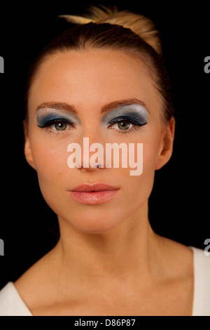 Belle jeune femme aux yeux verts portant un miroir bleu et rouge à lèvres Rose Banque D'Images